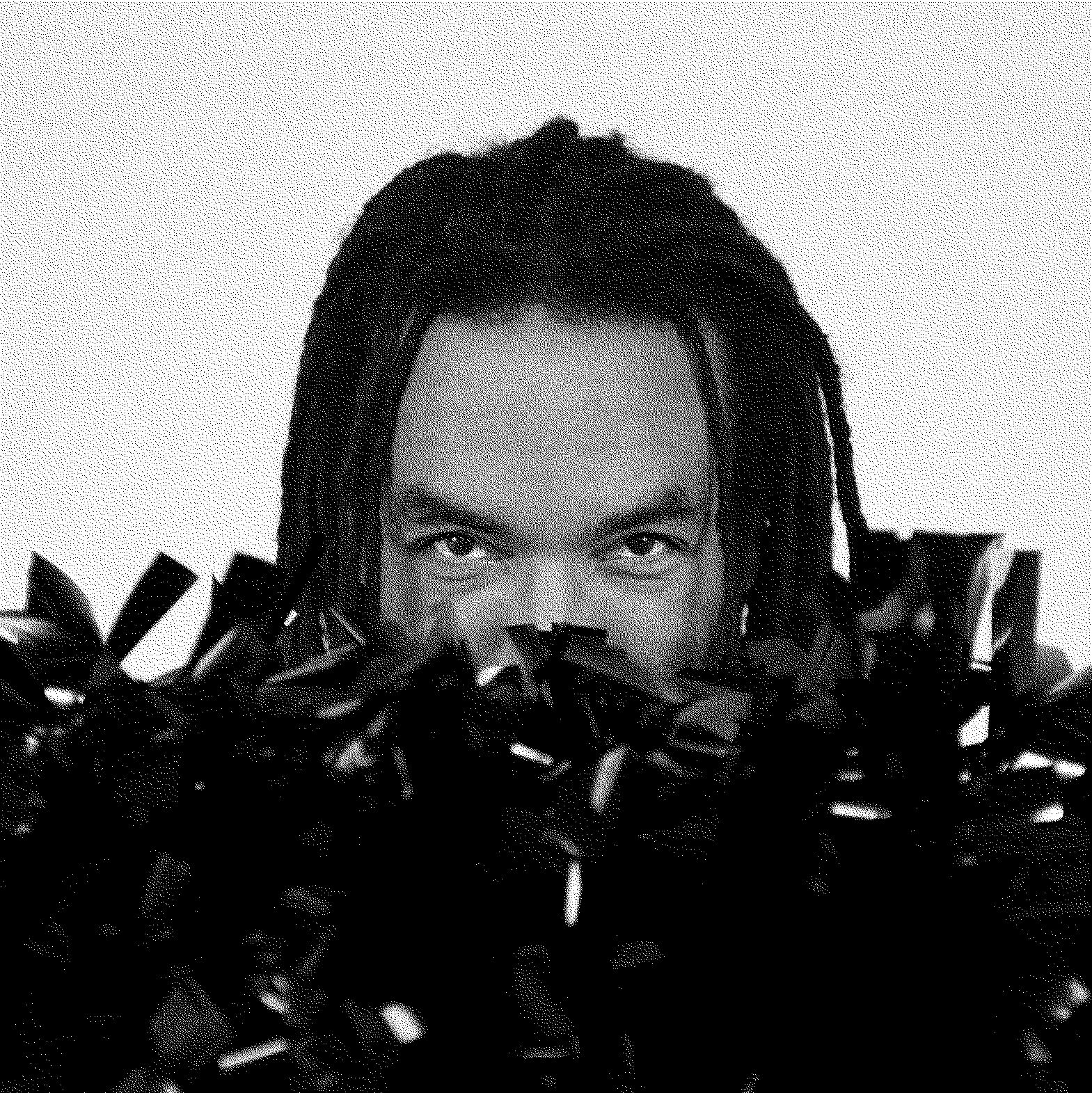 Photo d’une personne nous regardant avec la moitié du visage aché par des pompons